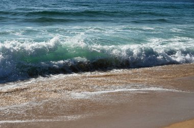 Okyanus dalgaları kumsalda kırılıyor
