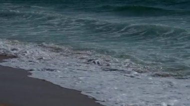 Okyanus dalgaları kumsalda kırılıyor