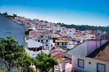 Alentejo Portekiz. 04 Ağustos 2024. Alentejo Portekiz 'de aldatmaca, beyazlatılmış evleri, terasotta çatıları ve yukarıdaki açık mavi gökyüzü ile büyüleyici tepe kenarı kasabası.