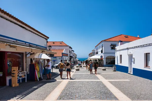 stock image Alentejo Portugal. 04 august 2024. Porto Covo in alentejo Portugal,  Charming cobblestone street in a Portuguese village with whitewashed houses, shops, and cafes.