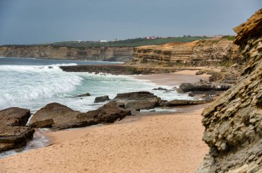 Portekiz 'in Ericeira kentindeki Pedra Branca sahilinde sörf ve doğal güzelliklerle bilinen vahşi Atlantik dalgaları çarpışıyor..