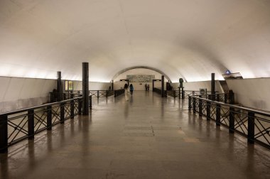 Lizbon, Portekiz. 14 Nisan 2025. Rato metro istasyonunun içi. Platformlara doğru geniş koridorda yürüyen insanlar var..