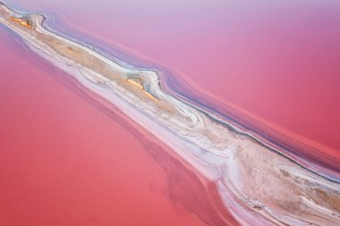 Aerial view of extremely salty lake with salt shelf in the pink water, natural abstract background, famous landmark near Henichesk, Ukraine