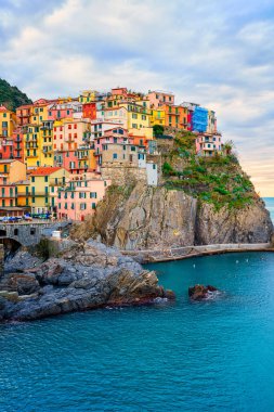 Stunning view of Manarola village in Cinque Terre National Park, beautiful cityscape with colorful houses and green terraces on cliffs over a sea, Liguria region of Italy. Outdoor travel background