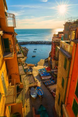 Riomaggiore şehir manzarası, ortaçağ mimarisi, renkli evler, gün batımında deniz ve balıkçı tekneleri, İtalya 'nın Liguria bölgesinde Cinque Terre Ulusal Parkı. Dış seyahat arka planı