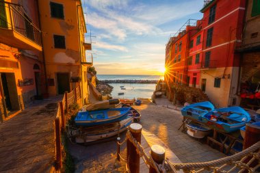 Riomaggiore şehir manzarası, ortaçağ mimarisi, renkli evler, gün batımında deniz ve balıkçı tekneleri, İtalya 'nın Liguria bölgesinde Cinque Terre Ulusal Parkı. Dış seyahat arka planı