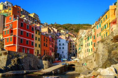 Cinque Terre Ulusal Parkı 'ndaki Riomaggiore köyünün manzarası, renkli evleri ve İtalya' nın Liguria bölgesindeki deniz kıyısındaki uçurumlarda yeşil terasları olan güzel şehir manzarası. Dış seyahat arka planı