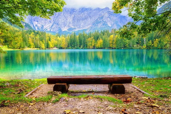 Laghi di Fusine aşağı göl, Tarvisio, İtalya. İnanılmaz sonbahar manzarası, yansımalı kristal berrak su ve renkli orman Mangart sıradağlarıyla çevrili, dış dünya seyahati arka planı.