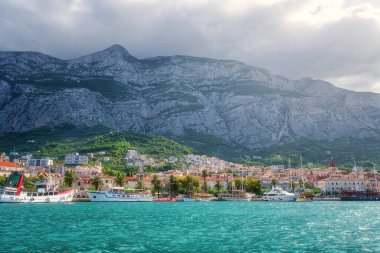 Liman ve Hırvatistan 'ın Dalmaçya kentinin eski Makarska kentinin manzarası. Yat, deniz, mimari ve kayalarla dolu yaz manzarası, Adriyatik sahil kıyısındaki ünlü turizm beldesi, seyahat arka planı