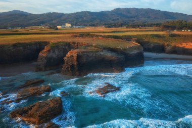 Aerial view of the Cathedrals beach (Playa de las Catedrales) or Praia de Augas Santas at sunrise, amazing landscape with rocks and Atlantic Ocean, Ribadeo, Galicia, Spain. Outdoor travel background clipart