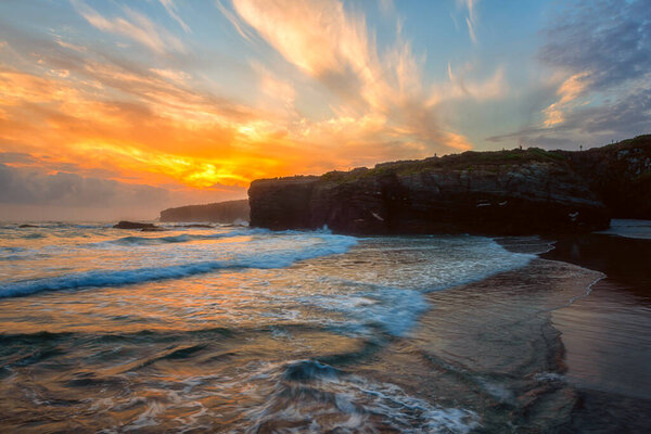 Cathedrals beach (Playa de las Catedrales) or Praia de Augas Santas at sunrise, amazing landscape with rocks on the Atlantic coast and colored sky, Ribadeo, Galicia, Spain. Outdoor travel background