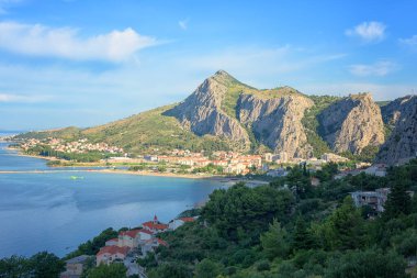 Omis 'in Adriyatik kıyısındaki manzarası, Dalmaçya, Hırvatistan. Sahil ve yeşilliklerle çevrili samimi bir kasaba Dinara dağları, dış seyahat geçmişi, turizm beldesi