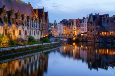 Belçika 'nın tarihi şehir merkezi Gent' in (Gent) manzarası. Ortaçağ mimarisi ile güzel şehir manzarası, anıtsal simgeler ve turist botları ile Lys nehri, dış seyahat arka planı