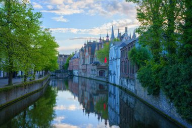 Eski Bruges Kasabası, Belçika, ünlü bir kent simgesi. Günbatımında Groenerei kanalı boyunca ortaçağ tarihi binaları olan manzaralı şehir manzarası.