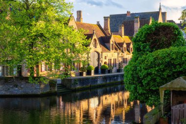 Eski Bruges Kasabası, Belçika, ünlü bir kent simgesi. Günbatımında Groenerei kanalı boyunca ortaçağ tarihi binaları olan manzaralı şehir manzarası.
