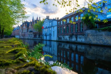 Eski Bruges Kasabası, Belçika, ünlü bir kent simgesi. Günbatımında Groenerei kanalı boyunca ortaçağ tarihi binaları olan manzaralı şehir manzarası.