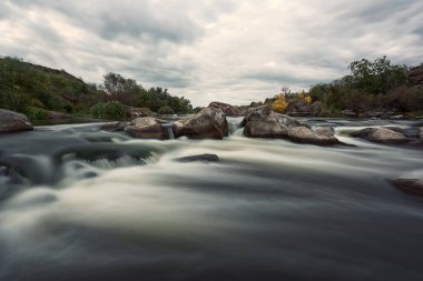 Dramatik doğa manzarası, Güney Böcek nehrinin manzaralı kanyonu tuhaf taşlar ve gri bulutlu gökyüzü, ulusal park Bugski Muhafızları, Mykolaiv bölgesi, Ukrayna. Dış seyahat arka planı