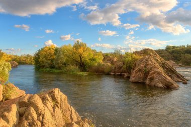 İnanılmaz doğa gündüz manzarası, Güney Böcek nehri manzaralı kayalık kanyon, bulutlu kayalar ve mavi gökyüzü, ulusal park Bugski Muhafızları, Mykolaiv bölgesi, Ukrayna. Dış seyahat arka planı