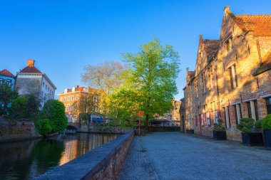 Eski Bruges kasabasının güzel manzarası, Belçika, ünlü bir yer. Günbatımında Groenerei kanalı boyunca ortaçağ tarihi binaları olan manzaralı şehir manzarası.