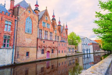 Eski Bruges kasabasının güzel manzarası, Belçika, ünlü bir yer. Günbatımında Groenerei kanalı boyunca ortaçağ tarihi binaları olan manzaralı şehir manzarası.