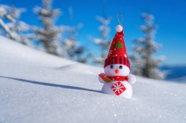 Kış manzarasında tatlı bir kardan adam, taze, yumuşak karlı dağlarda. Mutlu Noeller ve yeni yıl konsepti