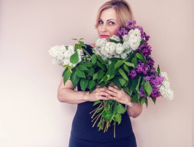 Kadınların elinde bir demet leylak. Kadın portresi