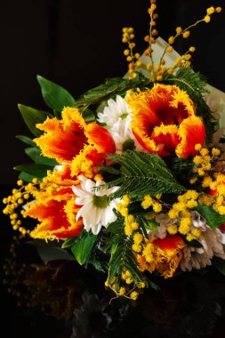Koyu arkaplanda renkli bahar çiçeği buketi