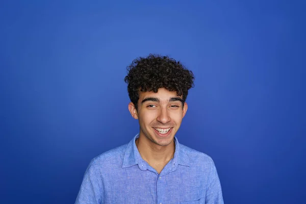 Mavi Arka Planda Gülümseyen Genç Bir Esmerin Portresi — Stok fotoğraf
