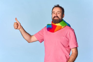 Sakallı biseksüel lgtb adamı lgtb gurur renginde bir eşarp takıyor. Karizmatik bir şekilde gülümse. Tamam sembol