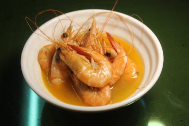 Kutlama partisi etkinliği. Tabakta karidesler pişiyor.