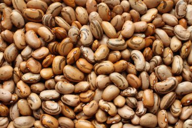 Yukarıdan bir yığın çiğ turuncu, bej kahverengi benekli fasulye. Yakın çekim.