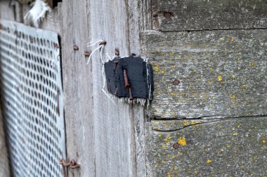 Eski paslı menteşeler kahverengi ahşap çatlamış kapı, makroyu kapat.