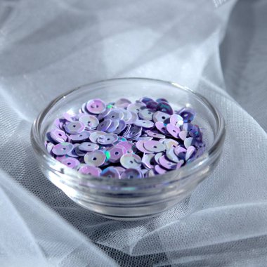 Parlak pembe pullar beyaz desenli arka plana saçılmış, üstteki makro fotoğrafı kapat.