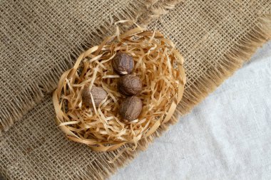 Kaba keten desenli arka plan görünümlü küçük sepetteki Nutmeg makrosu