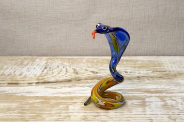 Kaba ahşap arka plan manzaralı camdan yılan figürü