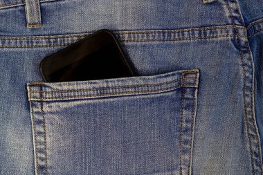 Cep telefonu ya da mavi kot pantolonlu akıllı telefon yakın plan