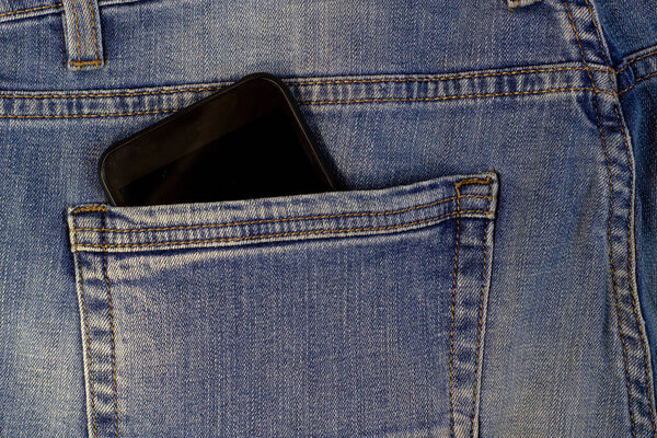 Mobile Phone or smartphone in blue jeans pocket close up