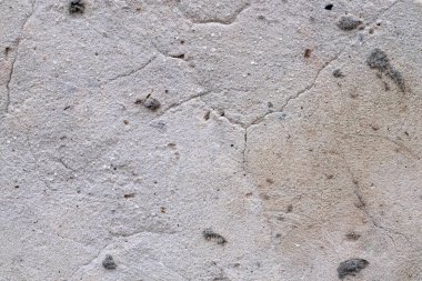 Çok eski bir beton duvarın dokusu, arka planda çatlaklar var.