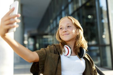 Yaz günü selfie çeken genç bir kız ya da akıllı telefondan cep telefonu konuşması yapan bir portre..