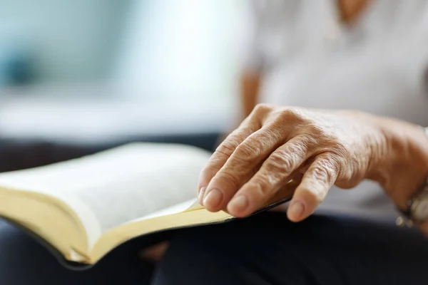 祈りの中で折り畳まれた聖書に手をシニア女性の閉鎖 — ストック写真