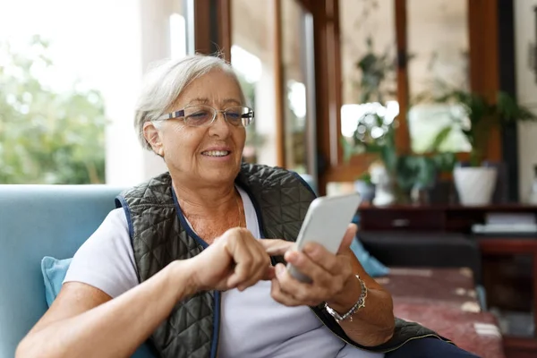 自宅のインテリアで携帯電話を使用して陽気先輩女性 自由と退職を楽しむ高齢女性 — ストック写真