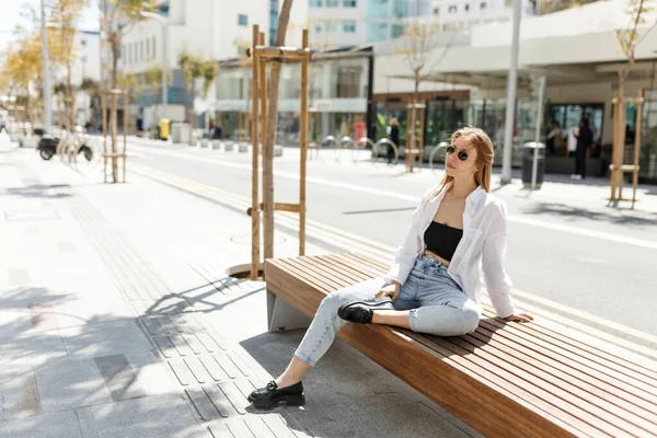 stock image Candid attractive young smiling woman sitting on bench in Cyprus street wearing casual clothes, happy mood, fashion style trend.