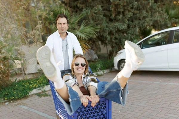 Mulher Feliz Sentado Dentro Carrinho Compras Homem Empurrando Carrinho Compras — Fotografia de Stock