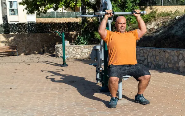 stock image Adult man exercising on the healthy park machine