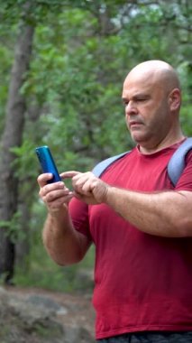 Ormandaki yürüyüşçü akıllı telefonu kullanarak ekrana dokunuyor.