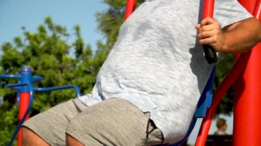 Biyolojik sağlık parkındaki makinede spor yapan bir adam.