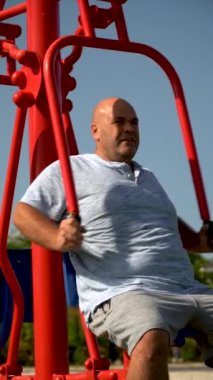 Biyolojik sağlık parkındaki makinede spor yapan bir adam.