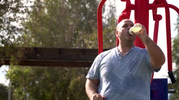 Один Человек Пьет Спортивную Воду Сидя Расслабленно Тренажерном Зале Открытом — стоковое видео