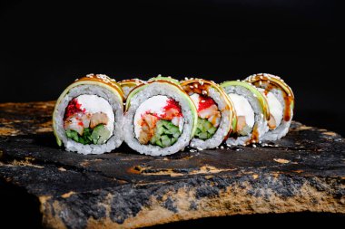 This appetizing photo showcases a sushi roll that is sure to make your mouth water. The roll is expertly crafted and features fresh ingredients, including rice, seaweed, and a variety of tasty