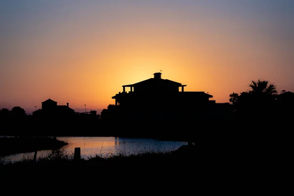 Siluetler, gün batımında ışığa karşı çekilen fotoğraf La Manga del Mar Menor, Murcia, İspanya